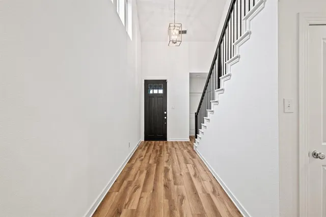 a view of a hallway with wooden floor and staircase