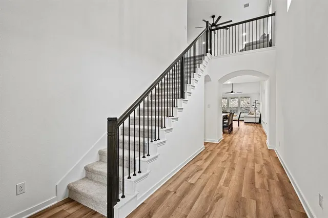 a view of a hallway with wooden floor and staircase