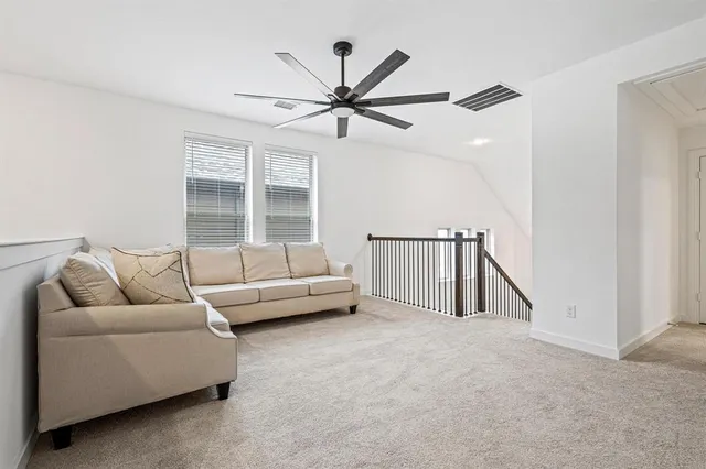 a living room with furniture and a ceiling fan