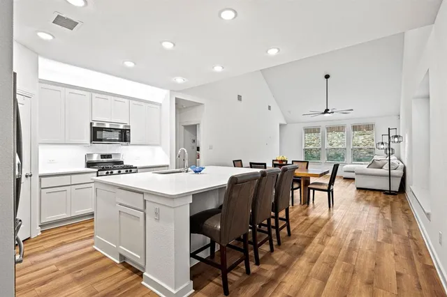 a kitchen with a table chairs refrigerator and cabinets