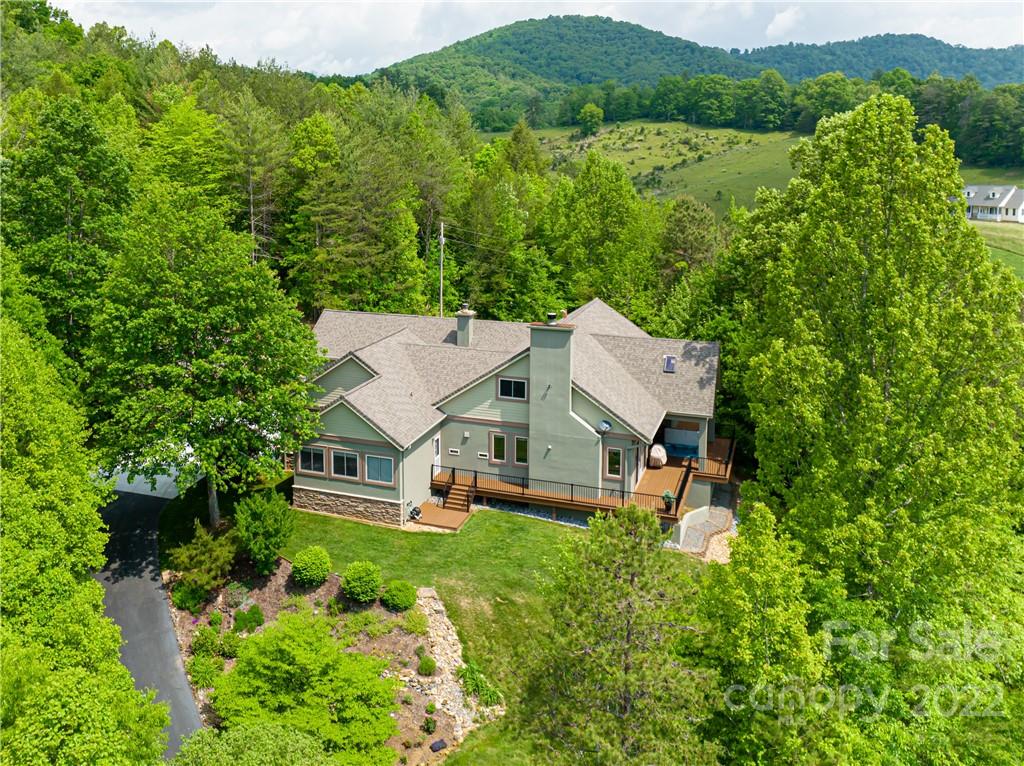 an aerial view of a house with pool and green space