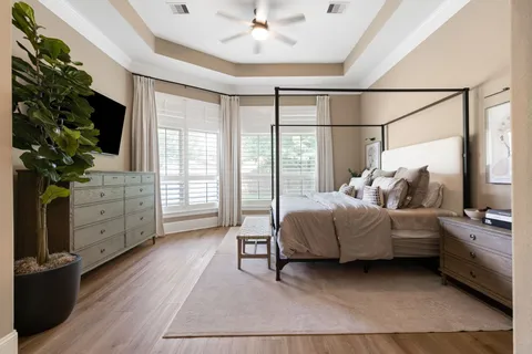 a bedroom with a bed and a flat tv screen on dresser