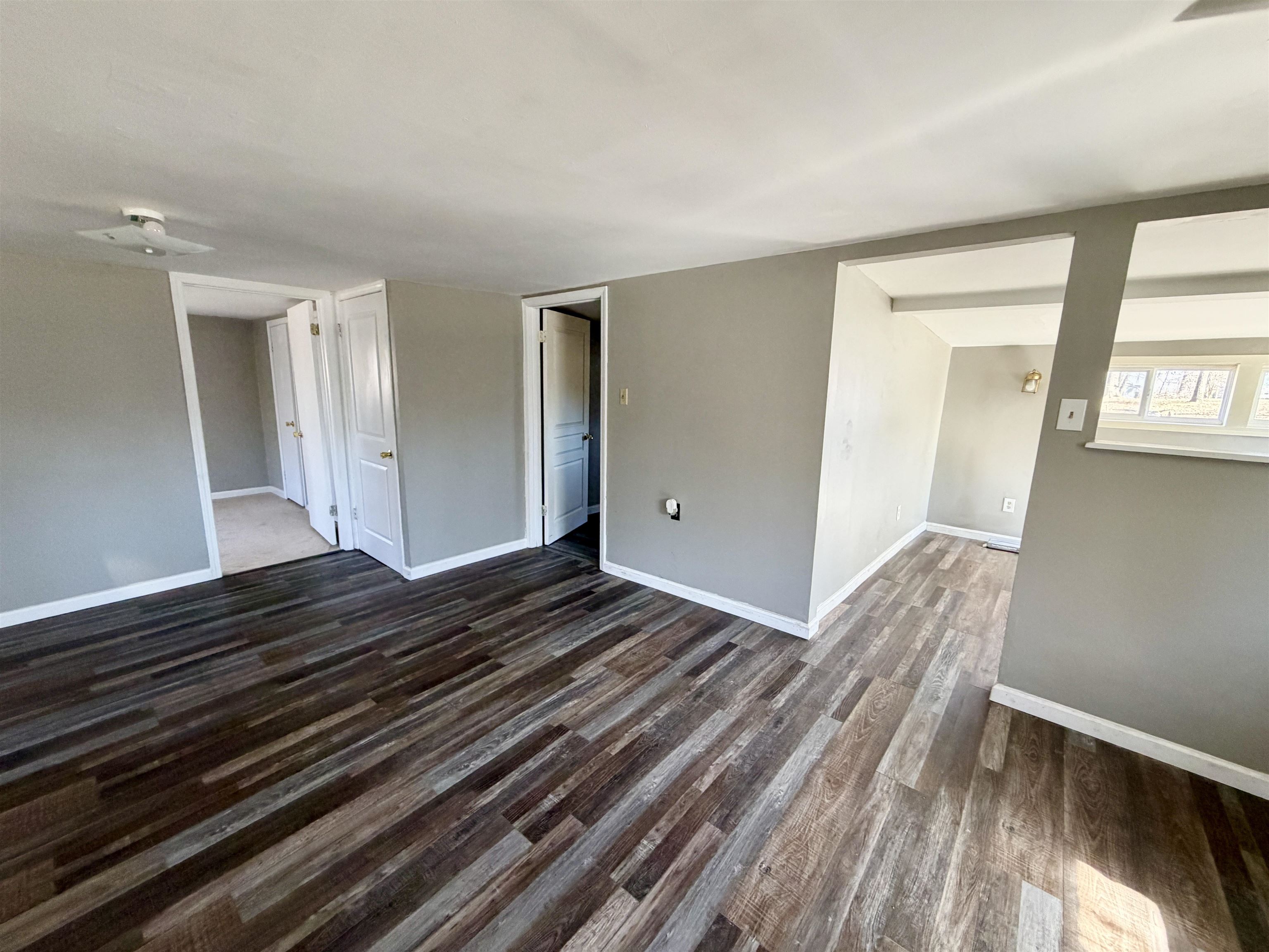 345 Shad Lane Adamsville, TN 38310 - Photo 4 of 20 Unfurnished living room with dark wood-type flooring and baseboards