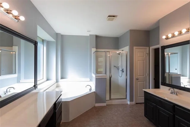 a bathroom with a tub sink shower and mirror