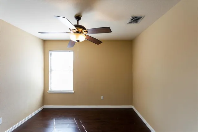 an empty room with a window and a fan