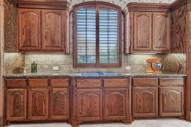 a large kitchen with granite countertop a sink and a stove