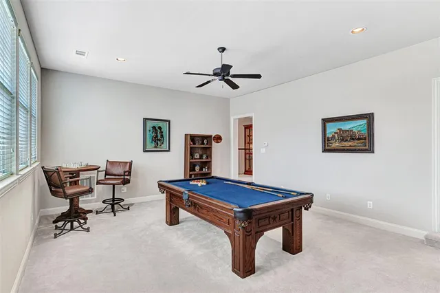 a room with furniture pool table and windows