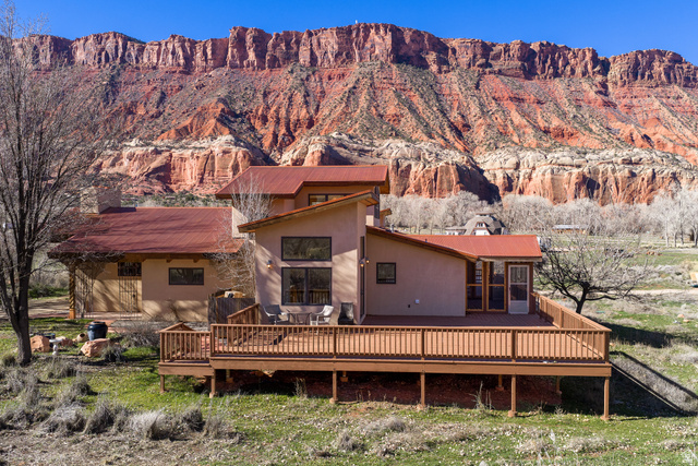 423 Amber Lane Moab, UT 84532 - Photo 3 of 63 East side of home with view of red rock cliffs in background