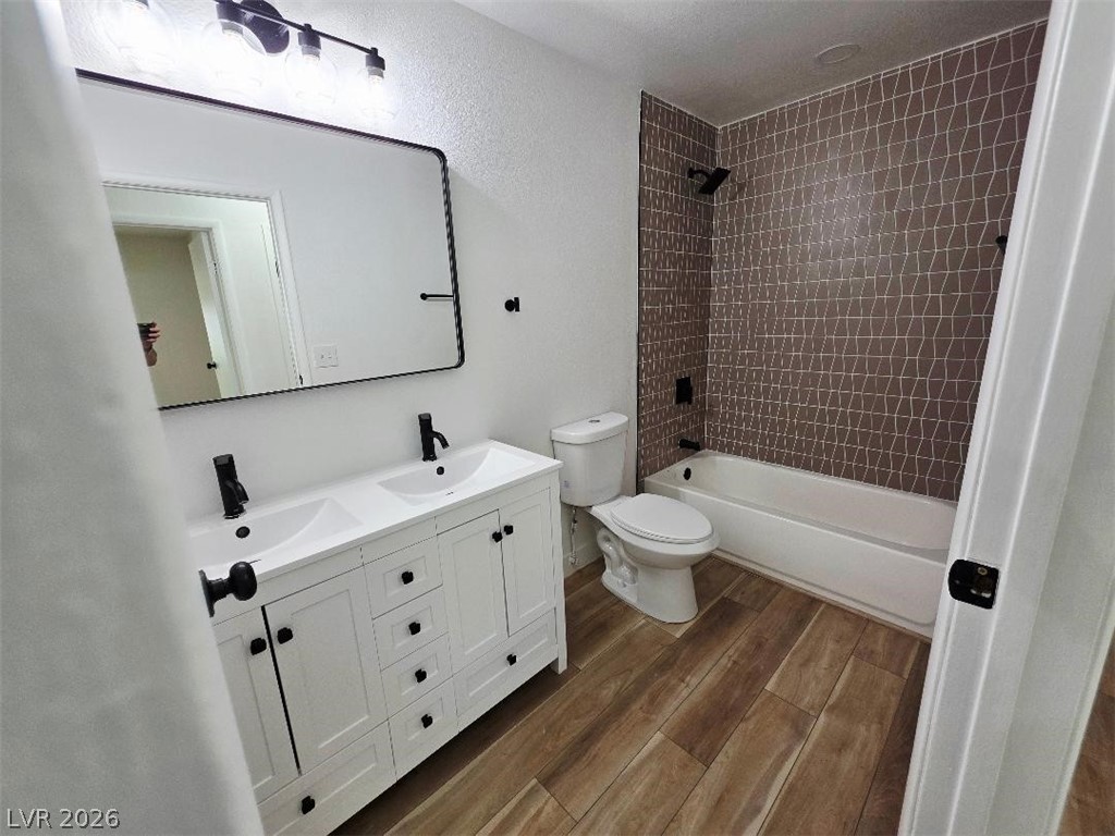 3420 West Warm Springs Road Las Vegas, NV 89118 - Photo 11 of 50 Full bath featuring double vanity, dark wood-style flooring, shower / washtub combination, and a textured wall