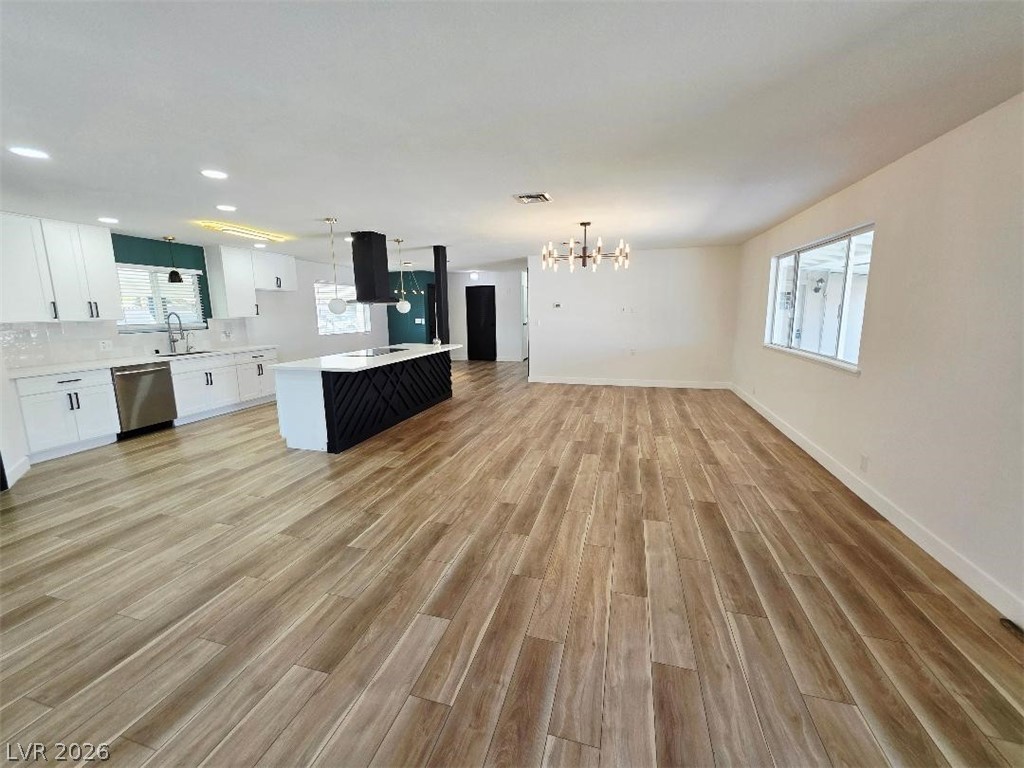 3420 West Warm Springs Road Las Vegas, NV 89118 - Photo 47 of 50 Kitchen with a kitchen island, open floor plan, white cabinets, light wood finished floors, and suspended lighting