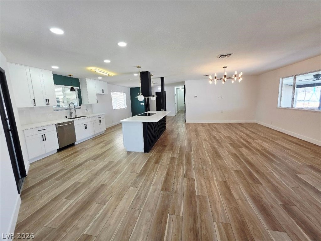 3420 West Warm Springs Road Las Vegas, NV 89118 - Photo 48 of 50 Kitchen with white cabinetry, light wood-style floors, a center island with sink, open floor plan, and suspended lighting