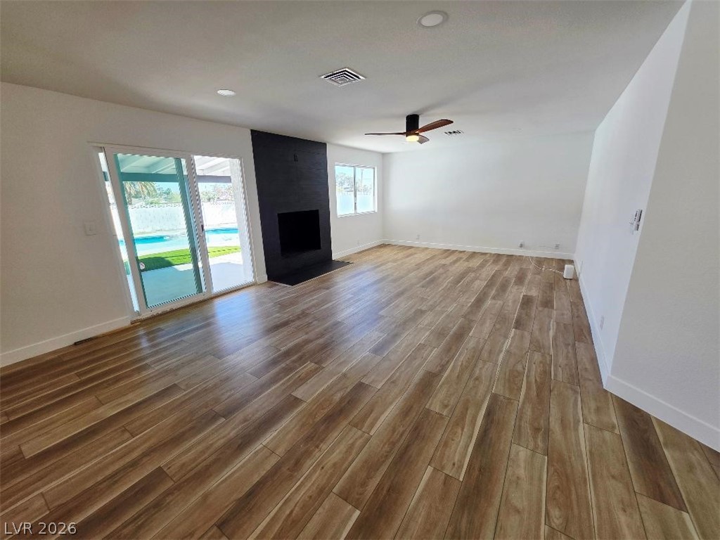 3420 West Warm Springs Road Las Vegas, NV 89118 - Photo 16 of 50 Large living room with a large fireplace, ceiling fan, dark wood finished floors, and recessed lighting, Brand new Gliding Patio door