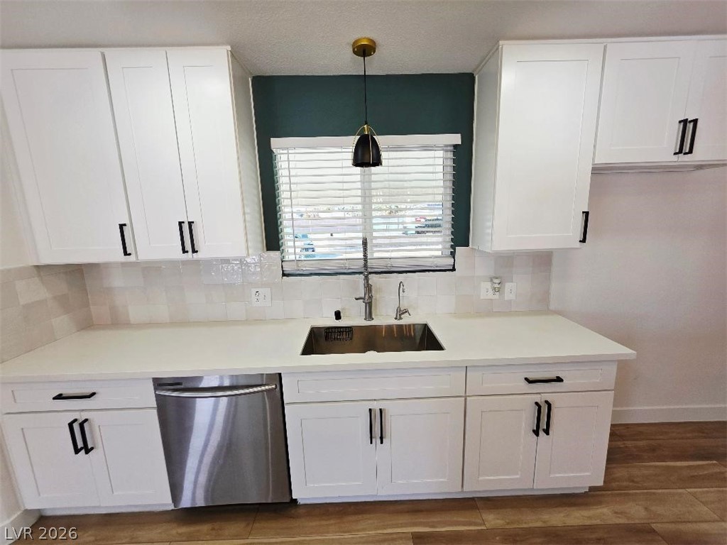 3420 West Warm Springs Road Las Vegas, NV 89118 - Photo 2 of 50 Kitchen featuring white cabinetry, stainless steel dishwasher, dark wood finished floors, and decorative light fixtures