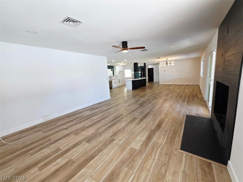 3420 West Warm Springs Road Las Vegas, NV 89118 - Photo 17 of 50 living room featuring light wood finished floors, ceiling fan, a fireplace, and hanging lights