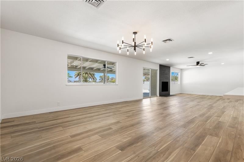 3420 West Warm Springs Road Las Vegas, NV 89118 - Photo 20 of 50 Super Large living room with ceiling fan, light wood-style flooring, suspended lighting, and a large fireplace