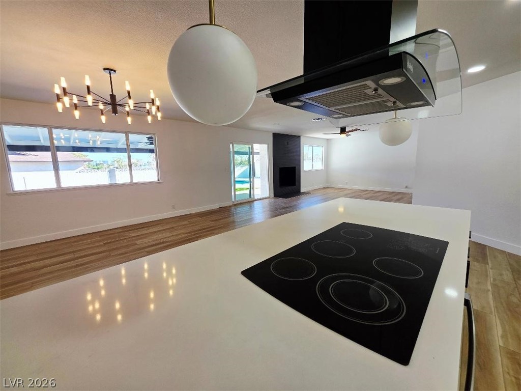 3420 West Warm Springs Road Las Vegas, NV 89118 - Photo 49 of 50 Kitchen with ventilation hood, black electric cooktop, open floor plan, suspended lighting, and light countertops