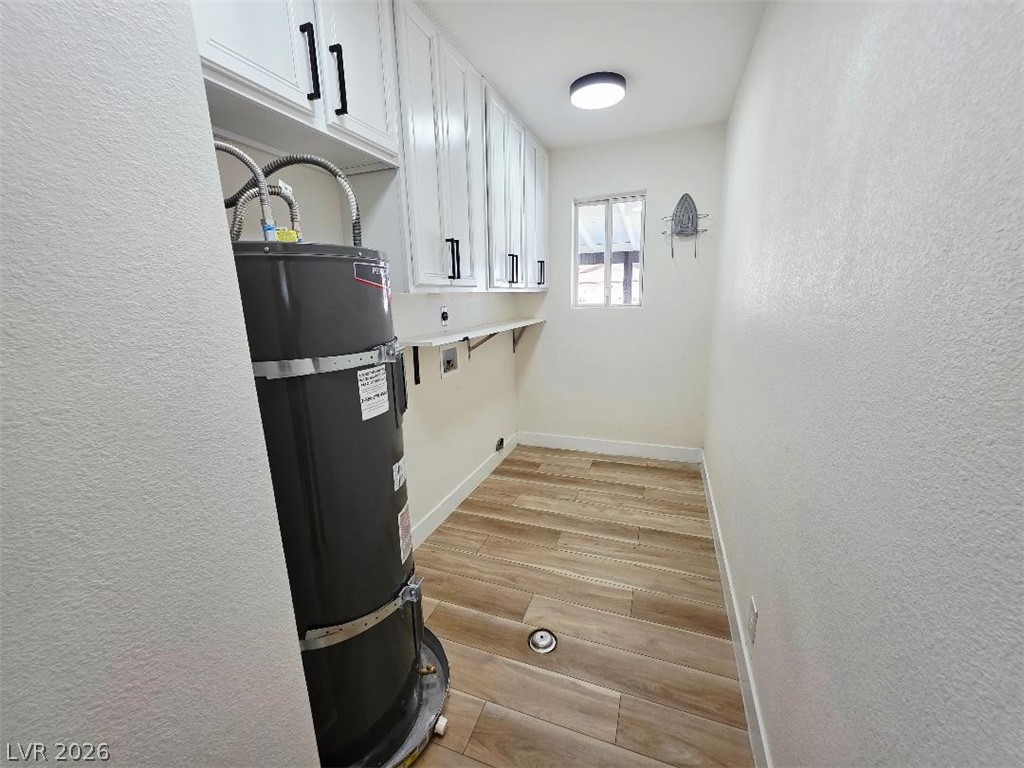 3420 West Warm Springs Road Las Vegas, NV 89118 - Photo 24 of 50 Laundry area featuring a textured wall, light wood finished floors, secured water heater, hookup for an electric dryer, and cabinet space