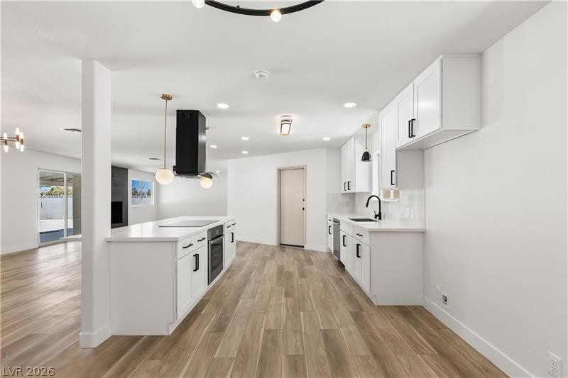3420 West Warm Springs Road Las Vegas, NV 89118 - Photo 3 of 50 Kitchen featuring white cabinetry, light wood-type flooring, exhaust hood, and decorative light fixtures