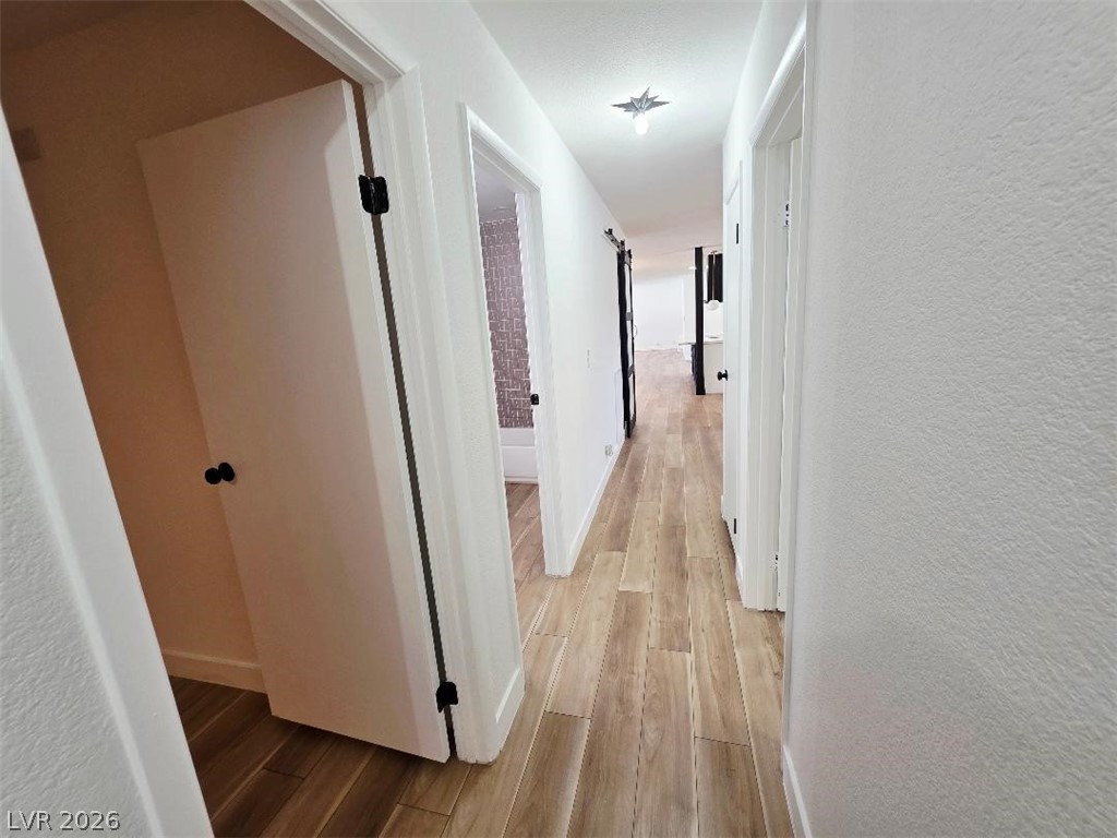 3420 West Warm Springs Road Las Vegas, NV 89118 - Photo 32 of 50 Hall with a textured wall and light wood-type flooring