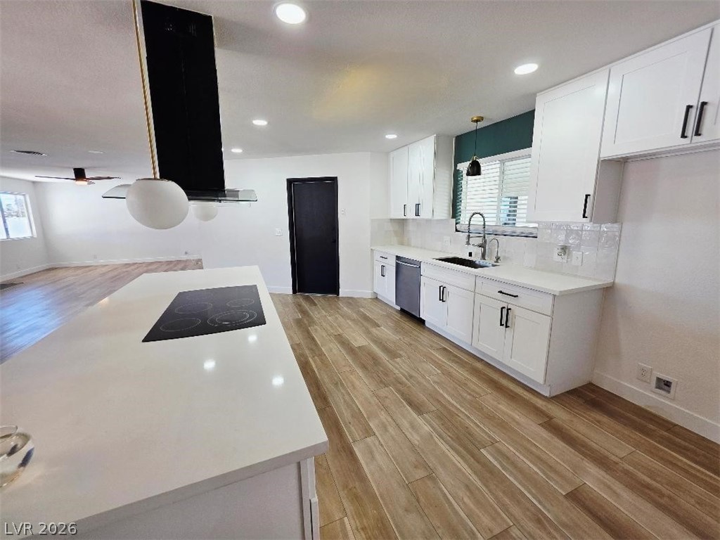 3420 West Warm Springs Road Las Vegas, NV 89118 - Photo 4 of 50 Kitchen featuring light wood-style flooring, pendant lighting, white cabinetry, exhaust hood, and black electric stovetop