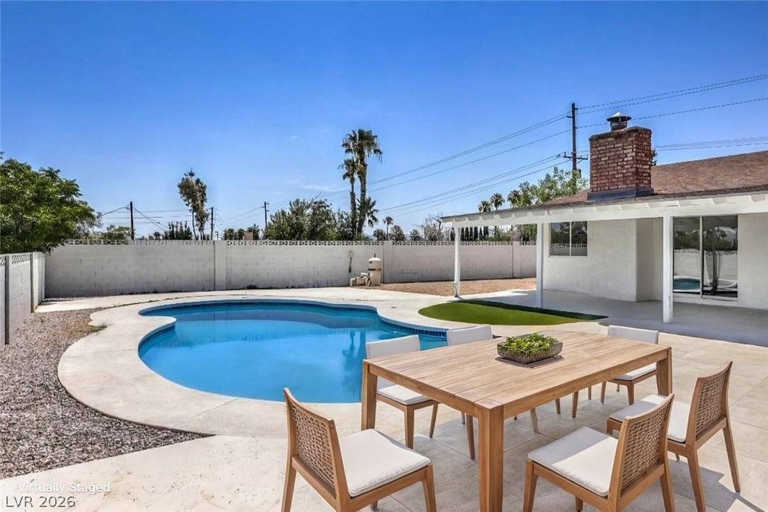 3420 West Warm Springs Road Las Vegas, NV 89118 - Photo 42 of 50 View of swimming pool featuring patio surround, a fenced backyard, and outdoor dining area