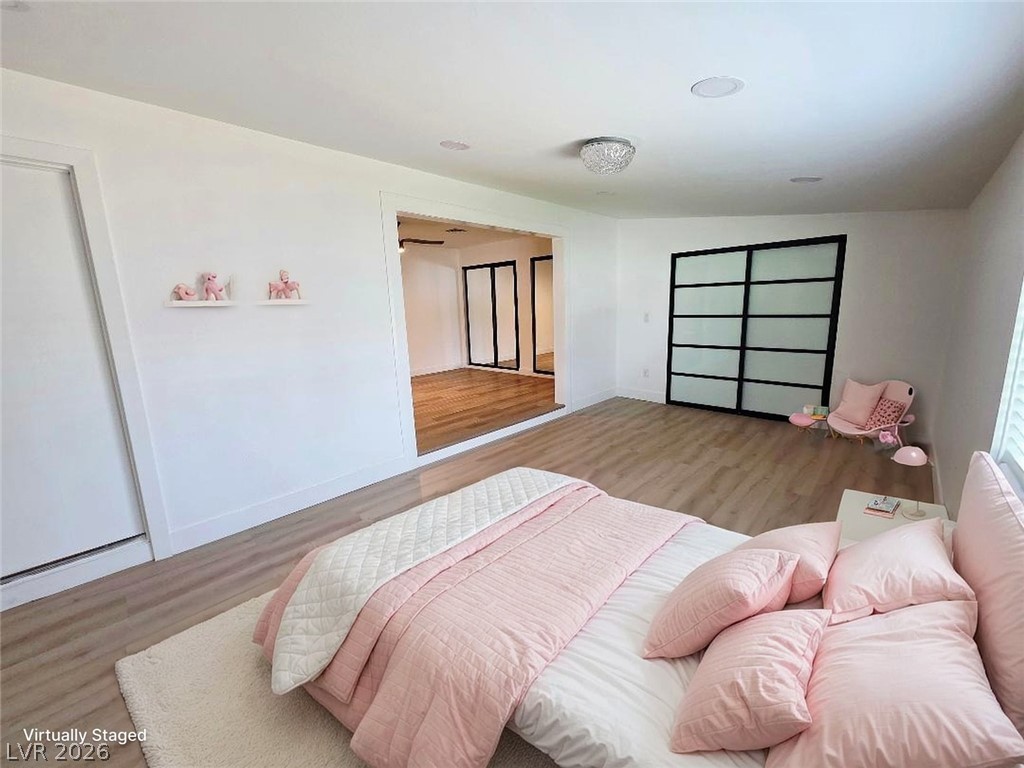 3420 West Warm Springs Road Las Vegas, NV 89118 - Photo 7 of 50 Bedroom 4 featuring light wood finished floors, recessed lighting, large closet and lofted ceiling use for Gym or office , off Primary Bedroom has a side entrance , Virtually stage