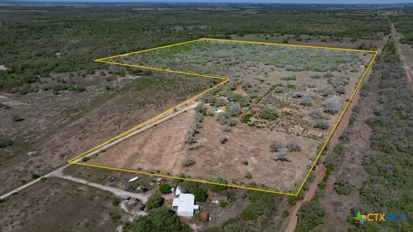 a view of a dry area with wooden fence