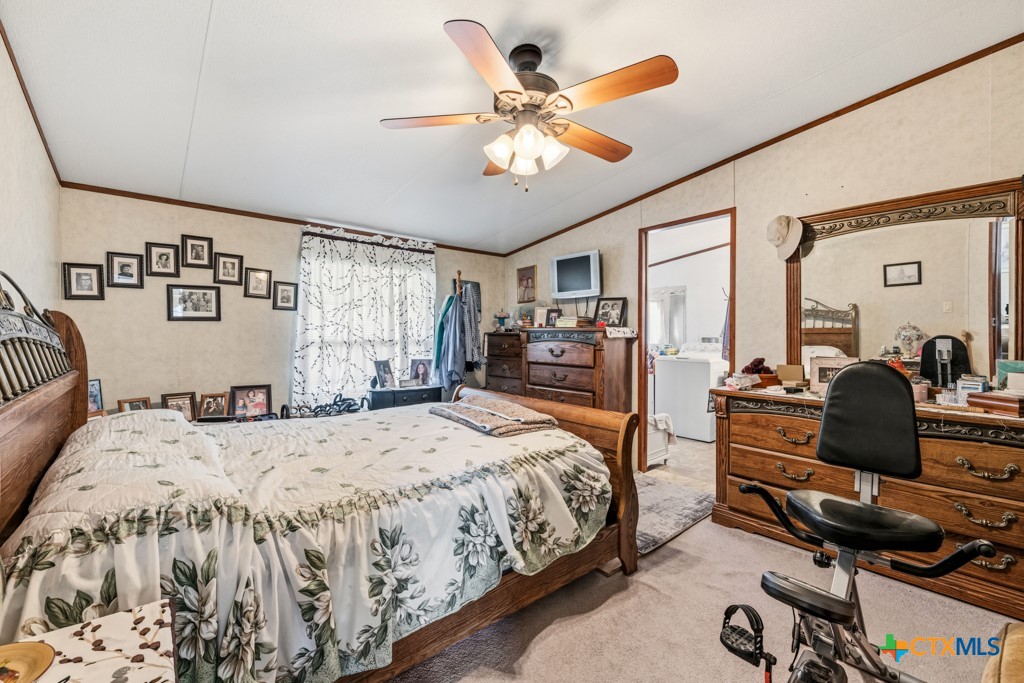 2632 Slickfield Road Yorktown, TX 78164 - Photo 13 of 33 a bedroom with a large bed a flat tv screen and dresser