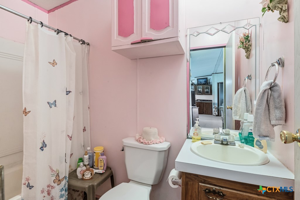 2632 Slickfield Road Yorktown, TX 78164 - Photo 16 of 33 a bathroom with a sink toilet and shower