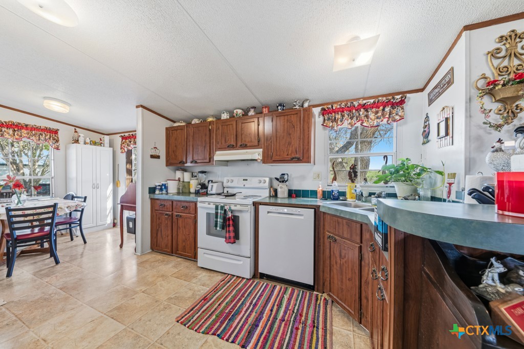 2632 Slickfield Road Yorktown, TX 78164 - Photo 9 of 33 a kitchen with stainless steel appliances a sink window and cabinets