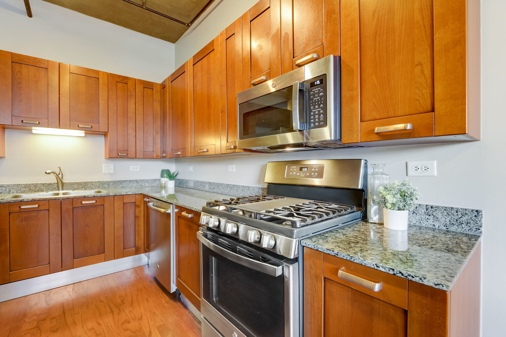 111 South Morgan Street, Unit 505 Chicago, IL 60607 - Photo 4 of 23 a kitchen with stainless steel appliances granite countertop a stove a sink and a microwave