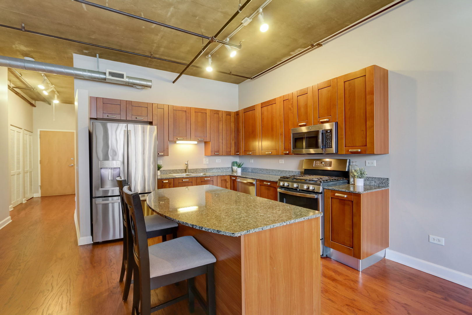 111 South Morgan Street, Unit 505 Chicago, IL 60607 - Photo 5 of 23 a kitchen with stainless steel appliances granite countertop a stove a refrigerator a sink a stove and island