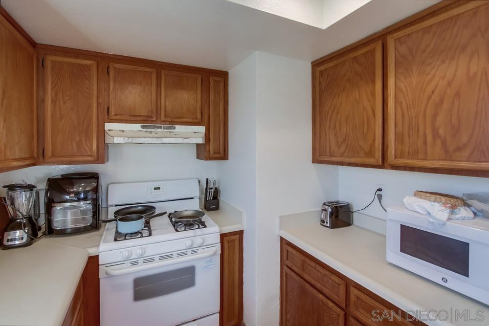 1122 11th Street Imperial Beach, CA 91932 - Photo 21 of 23 a kitchen with stainless steel appliances wooden cabinets and a stove top oven