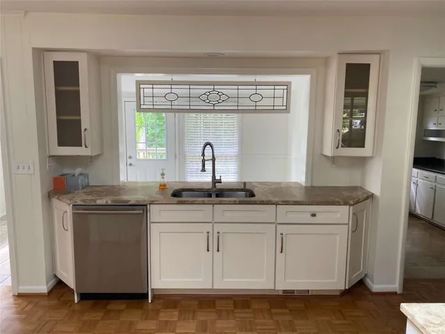 a kitchen with stainless steel appliances granite countertop a sink and a stove next to a window