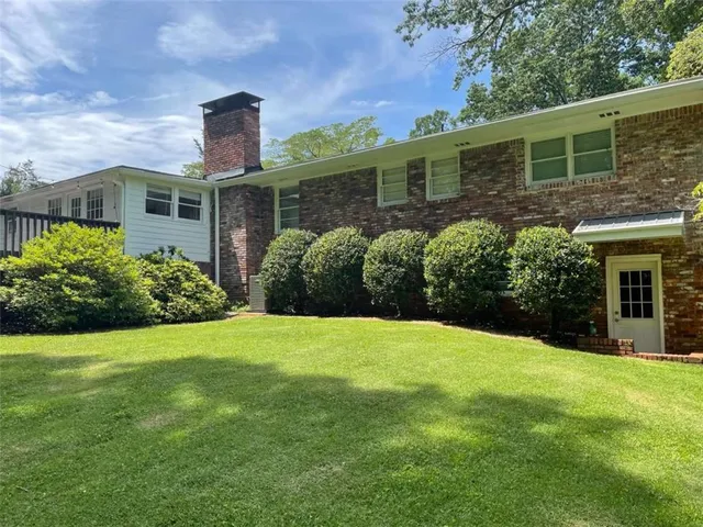 a view of a house with a backyard and a patio