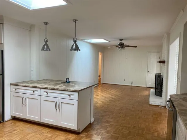 a view of a kitchen with a sink and wooden floor