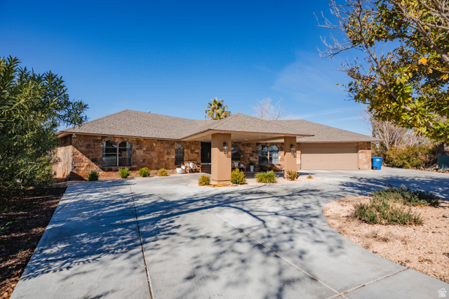 980 Cactus Circle St. George, UT 84790 - Photo 73 of 77 Single story home featuring curved driveway, a garage, roof with shingles, and stone siding