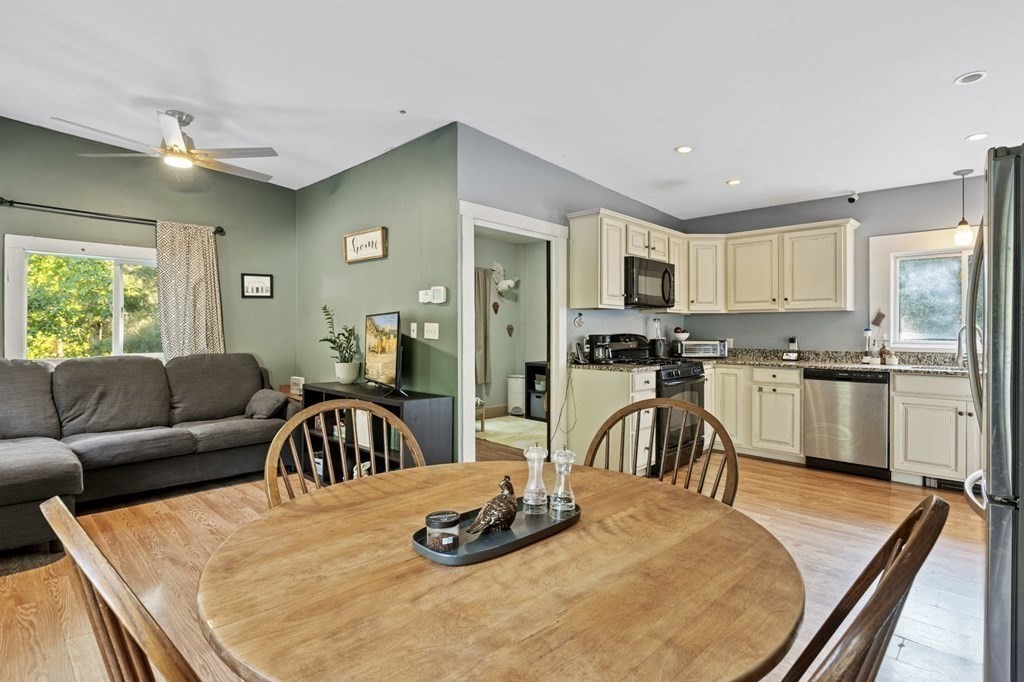 8 Squirrel Road Plymouth, MA 02360 - Photo 13 of 42 a kitchen with granite countertop a refrigerator a stove a sink a dining table and chairs with wooden floor