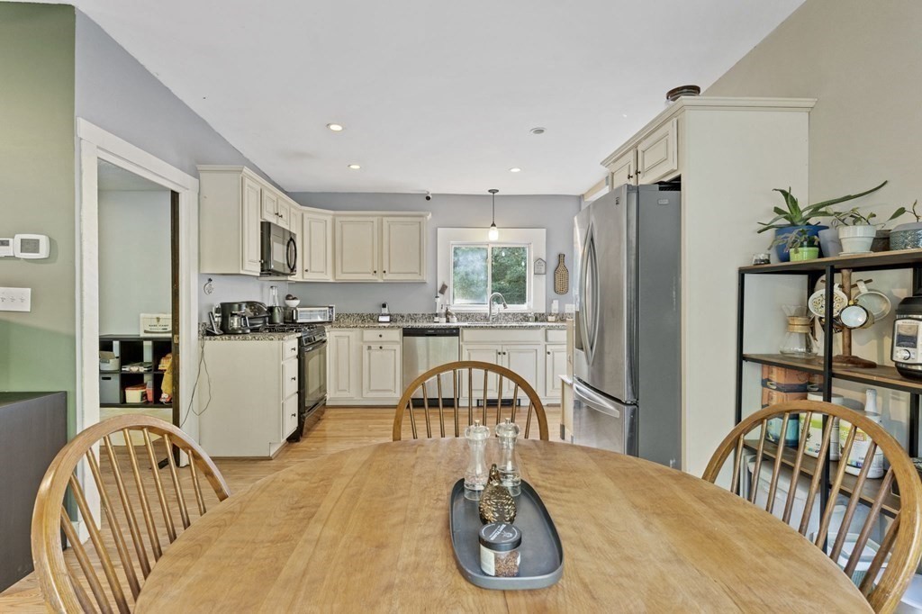 8 Squirrel Road Plymouth, MA 02360 - Photo 15 of 42 a kitchen with a table chairs a refrigerator and a window