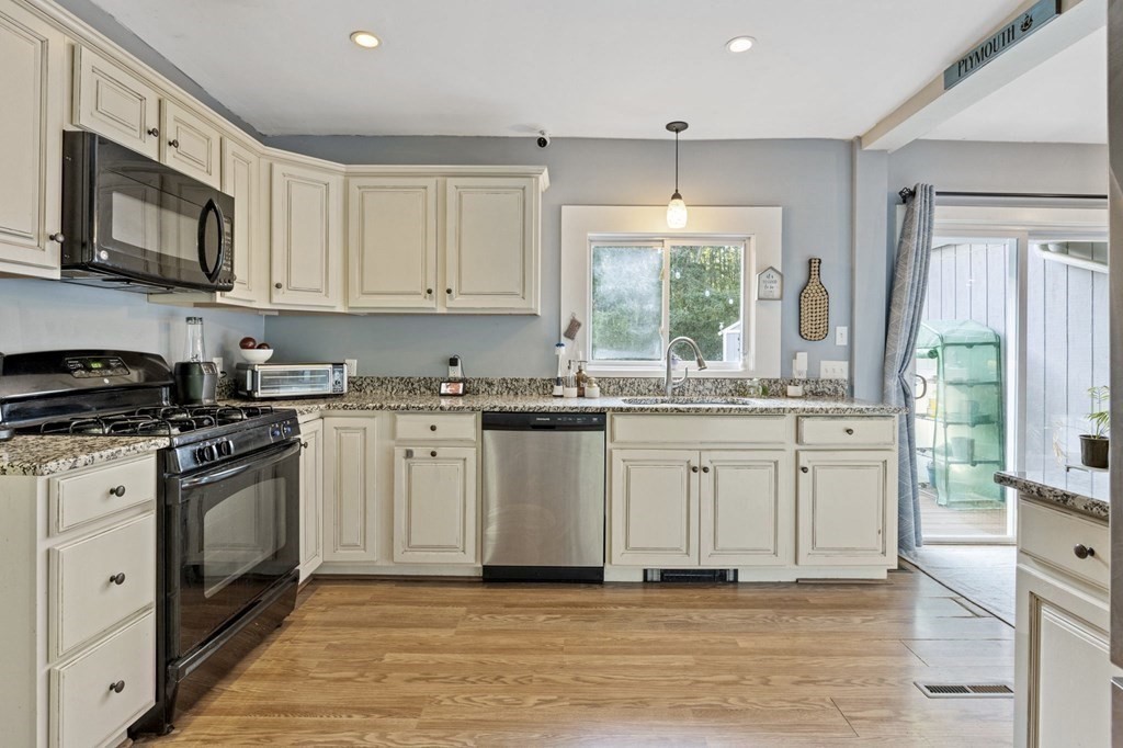8 Squirrel Road Plymouth, MA 02360 - Photo 16 of 42 a kitchen with stainless steel appliances granite countertop a stove a sink dishwasher a refrigerator and a microwave oven with wooden floor