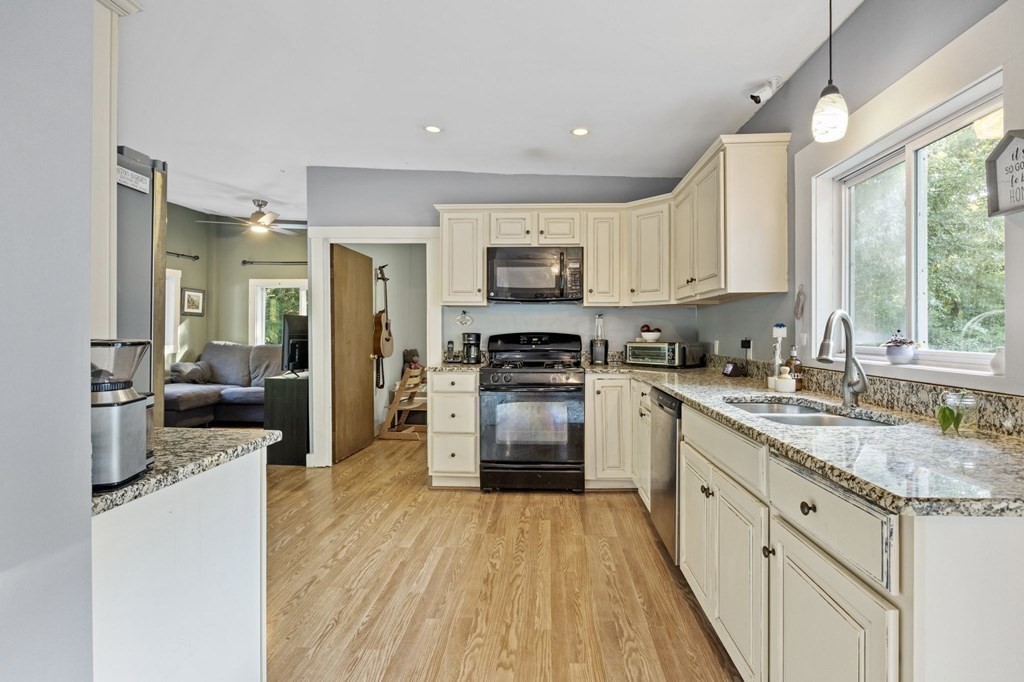 8 Squirrel Road Plymouth, MA 02360 - Photo 18 of 42 a kitchen with kitchen island granite countertop a stove top oven a sink dishwasher a dining table and chairs with wooden floor