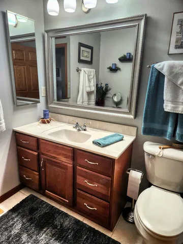 a bathroom with a toilet sink and mirror