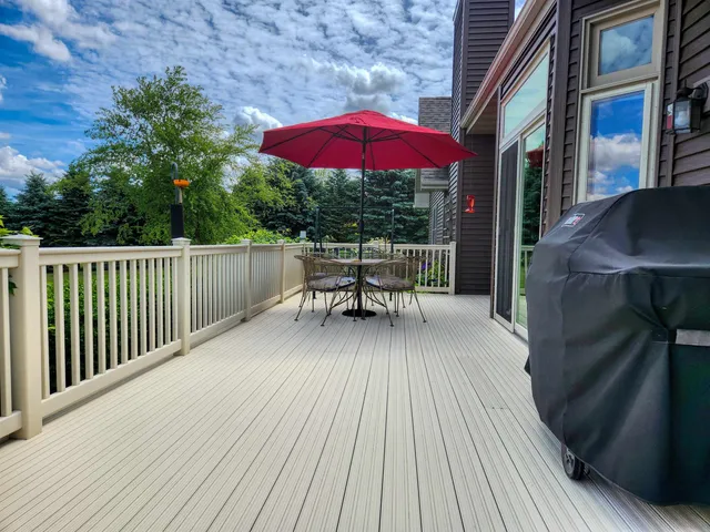 a balcony with wooden floor table and chairs