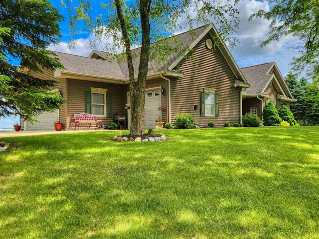 a front view of a house with a yard and trees