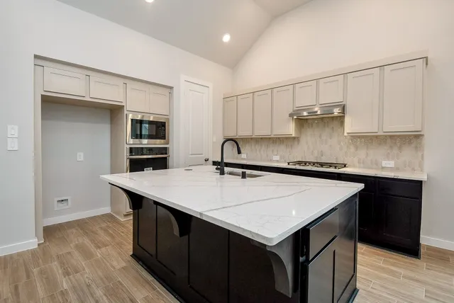 a kitchen with a sink a stove a microwave and cabinets