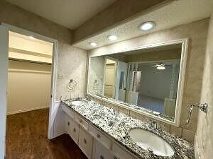 3206 77th Street Lubbock, TX 79423 - Photo 16 of 35 a bathroom with a granite countertop sink a mirror and a shower