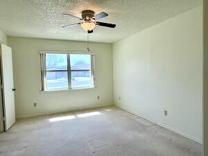 3206 77th Street Lubbock, TX 79423 - Photo 18 of 35 an empty room with windows and chandelier fan