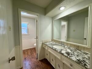 3206 77th Street Lubbock, TX 79423 - Photo 21 of 35 a bathroom with a granite countertop sink and a mirror