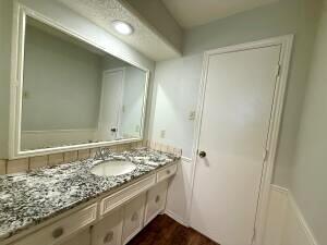 3206 77th Street Lubbock, TX 79423 - Photo 22 of 35 a bathroom with a granite countertop sink and a mirror