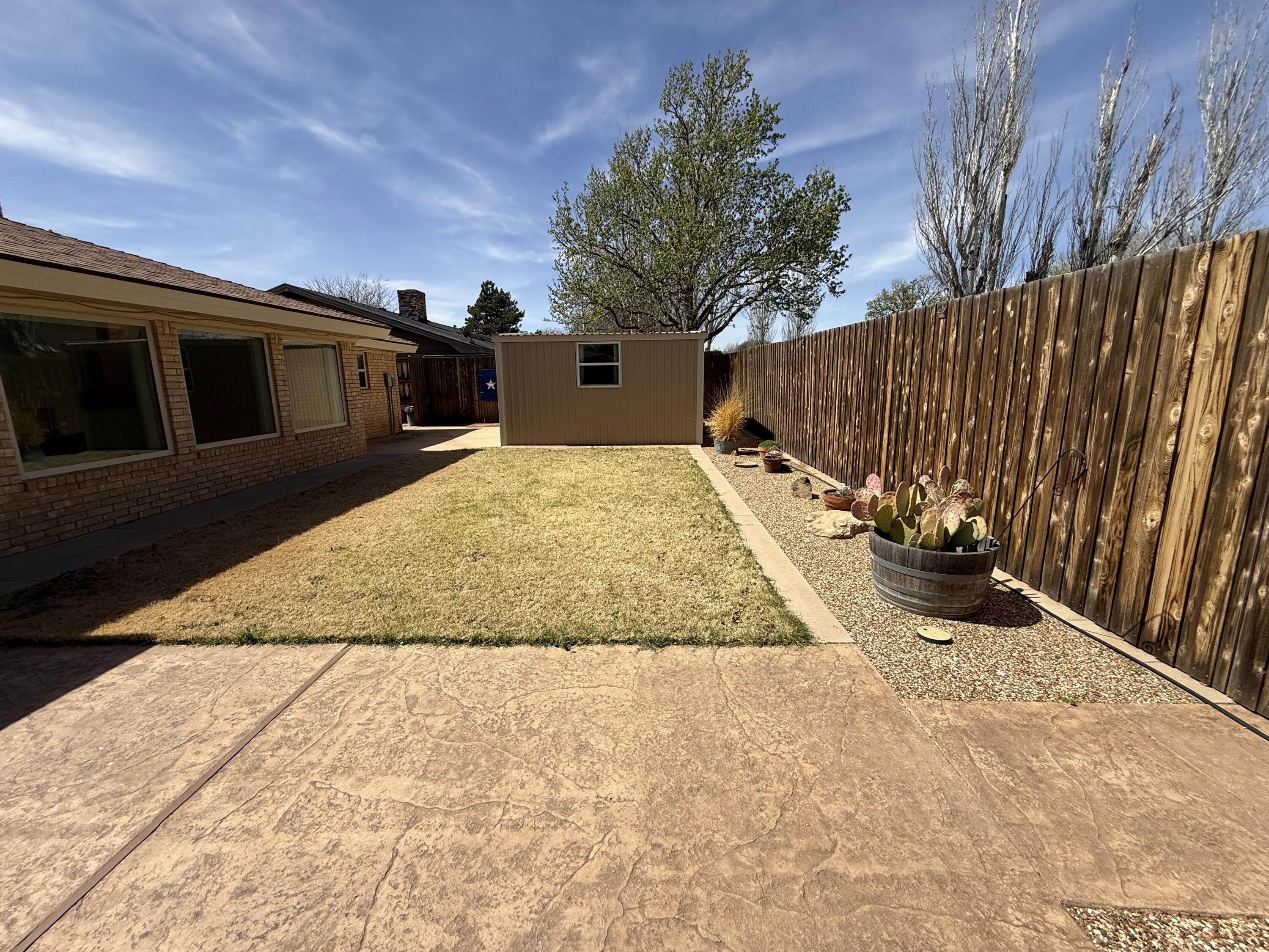3206 77th Street Lubbock, TX 79423 - Photo 27 of 35 a view of backyard with potted plants and a large tree